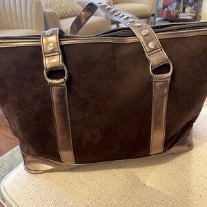 Suede handbag with metallic straps. Polyester fabric interior.